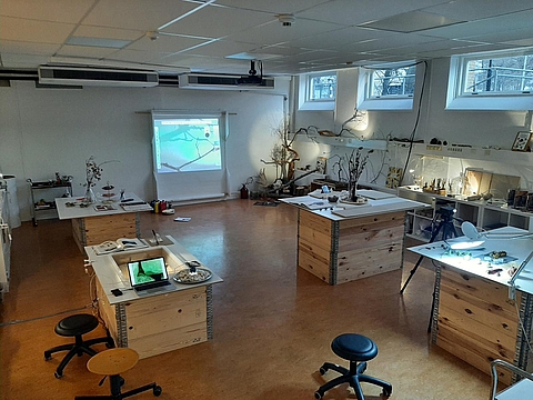 Atelier Raum mit Tischen, Stühlen, Wandprojektion